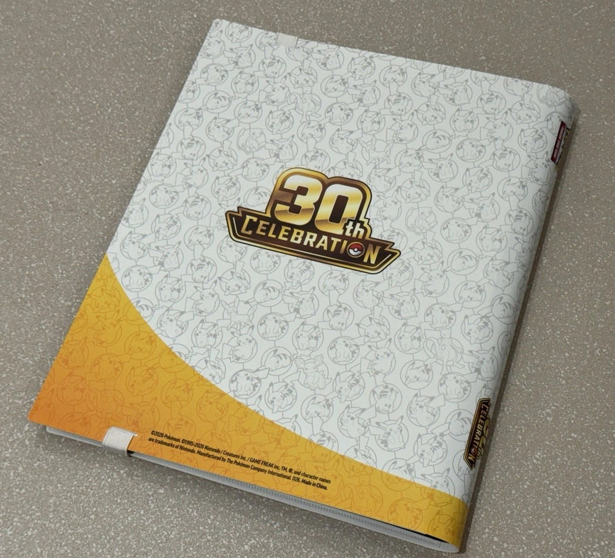 30th Celebration binder back cover at an angle showing the gold logo and product details