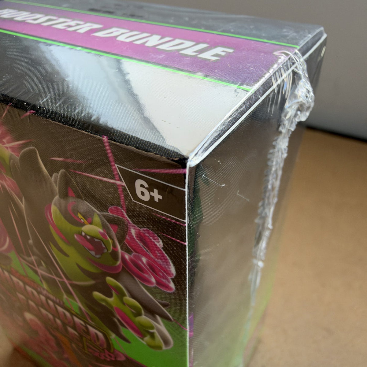 Close-up of the factory shrink wrap on a sealed Pokemon TCG booster bundle